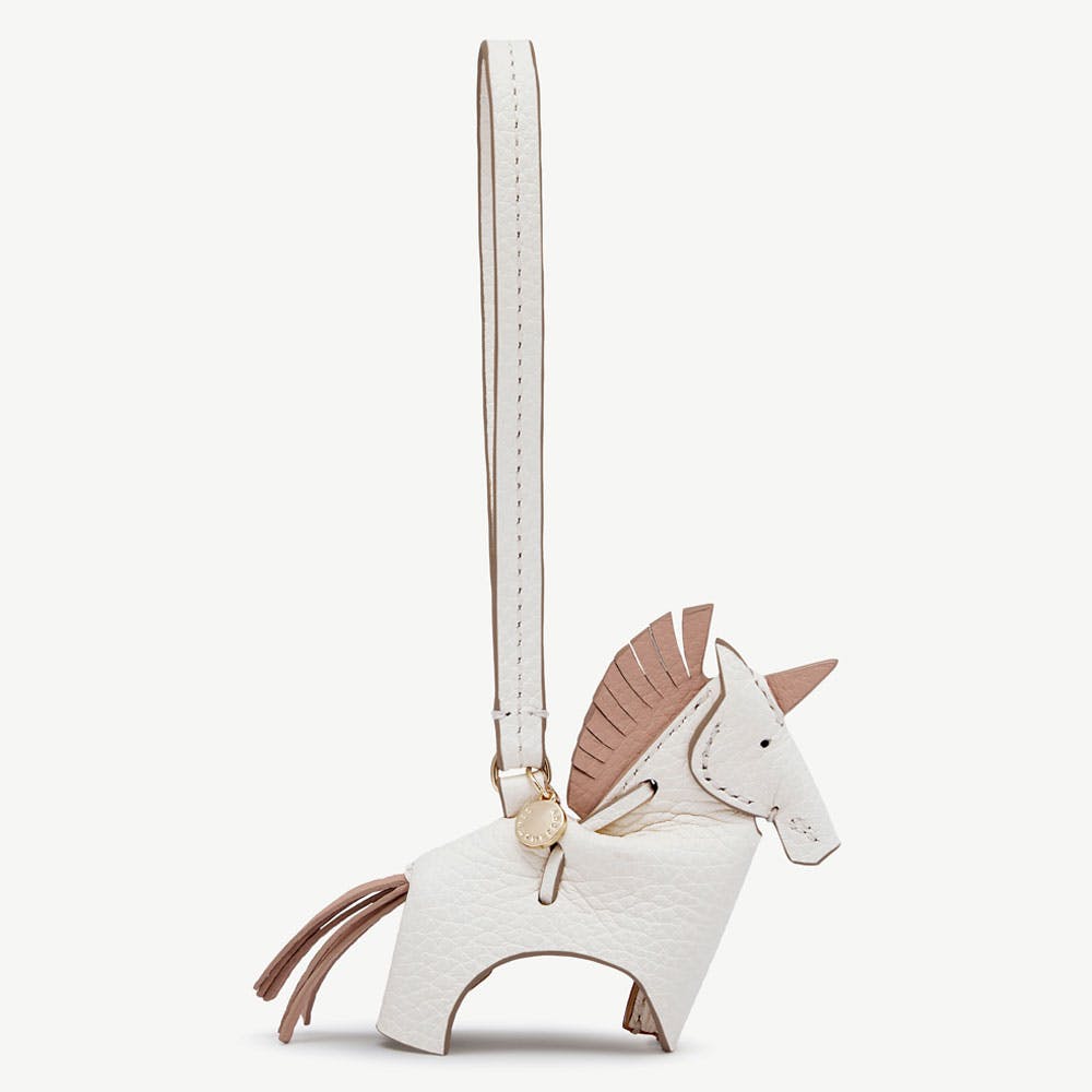 White leather unicorn bag charm with peony-coloured mane and long strap.