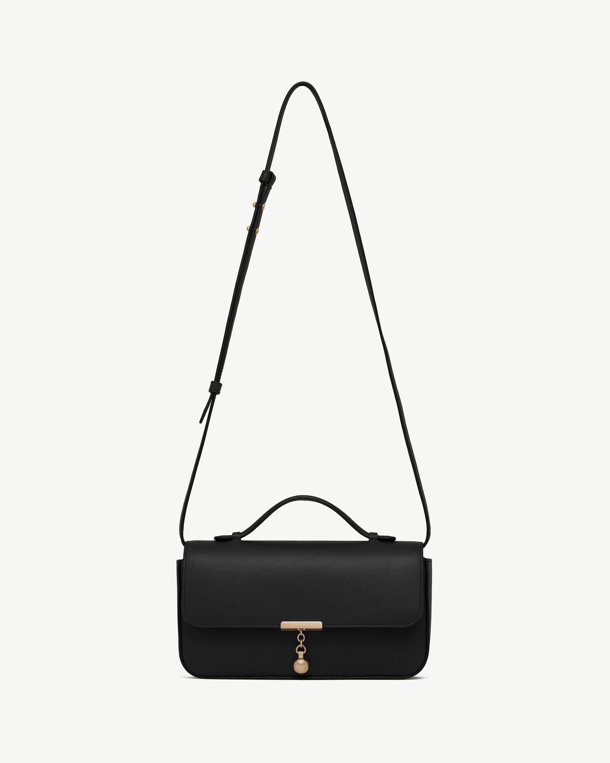 Black Nocturn clutch with top handle, adjustable shoulder strap and gold charm.