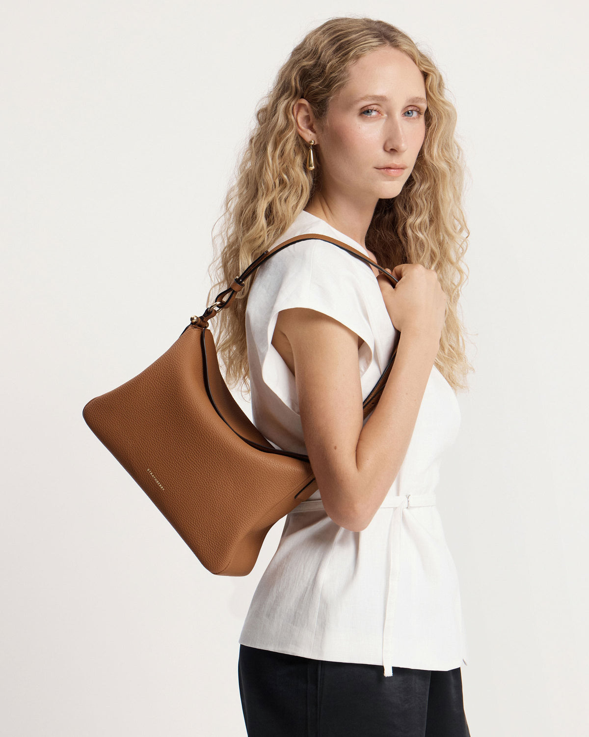 Model wearing a tan Strathberry Sway Maxi shoulder bag over her shoulder