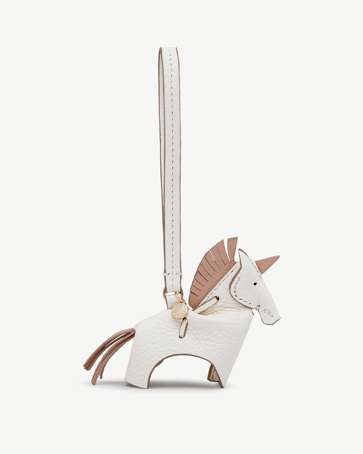 White leather unicorn bag charm with peony mane, gold medallion, and strap.